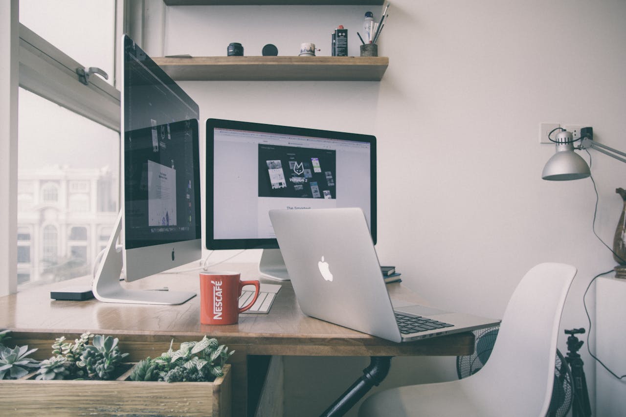 our-story Sleek home office setup with dual monitors, a laptop, and minimalist decor.